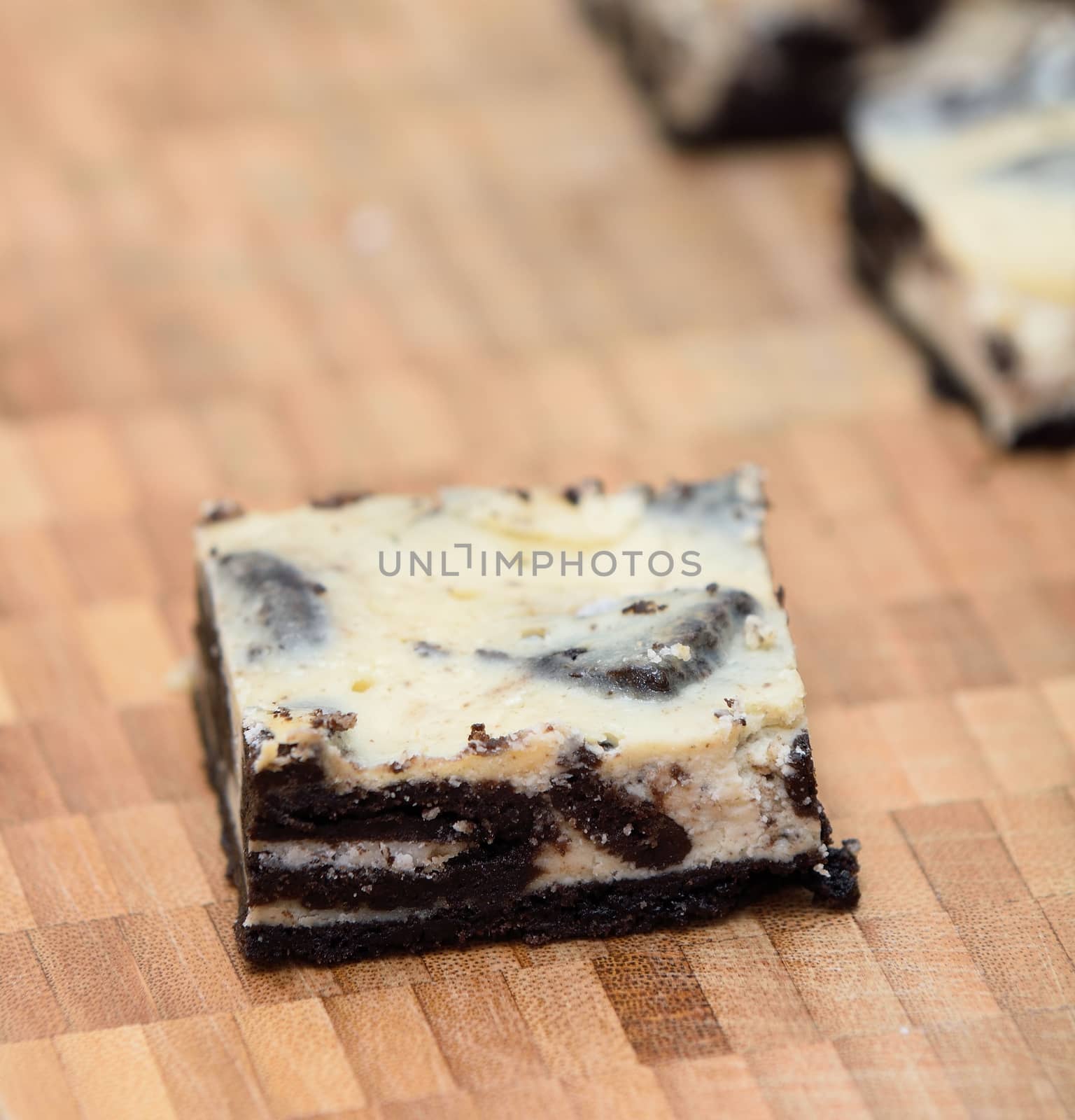 Peace of cheesecake with oreo biscuit base on the wooden plate.