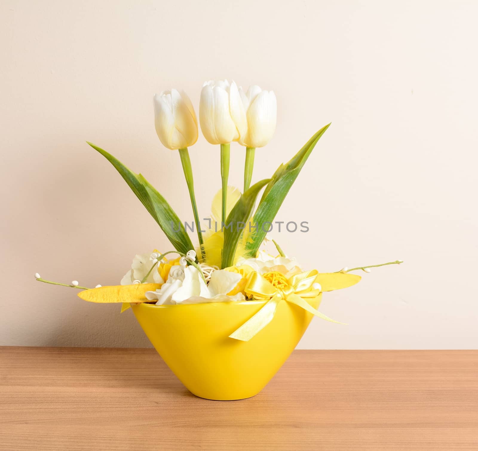 Interior decoration, decorative white tulips in the yellow flowerpot.