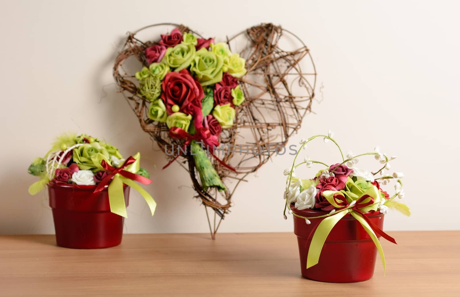 Interior decoration, decorative set with wicker heart and red flowerpot with rose.