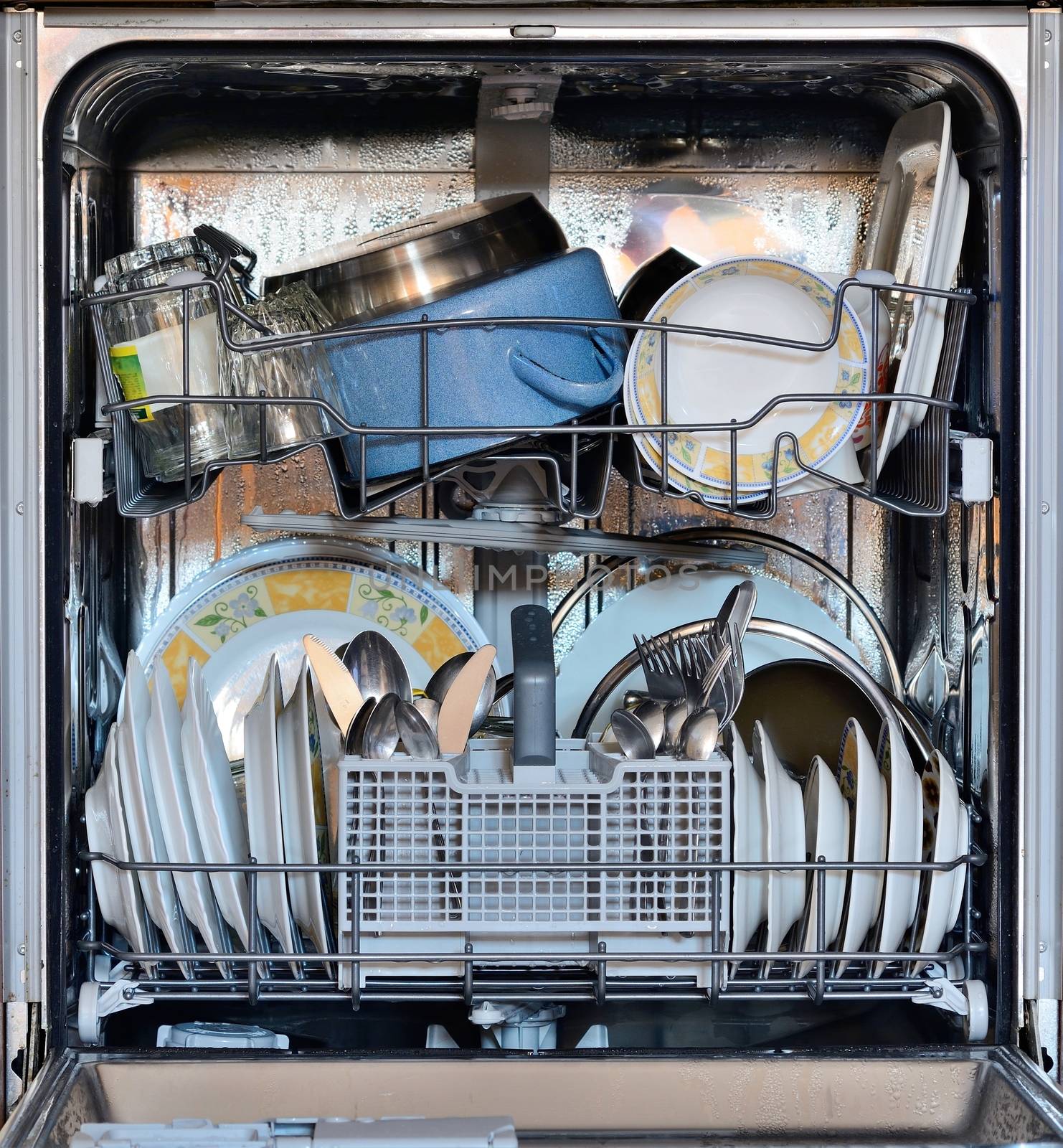 Open the front door of the dishwasher full of clean dishes