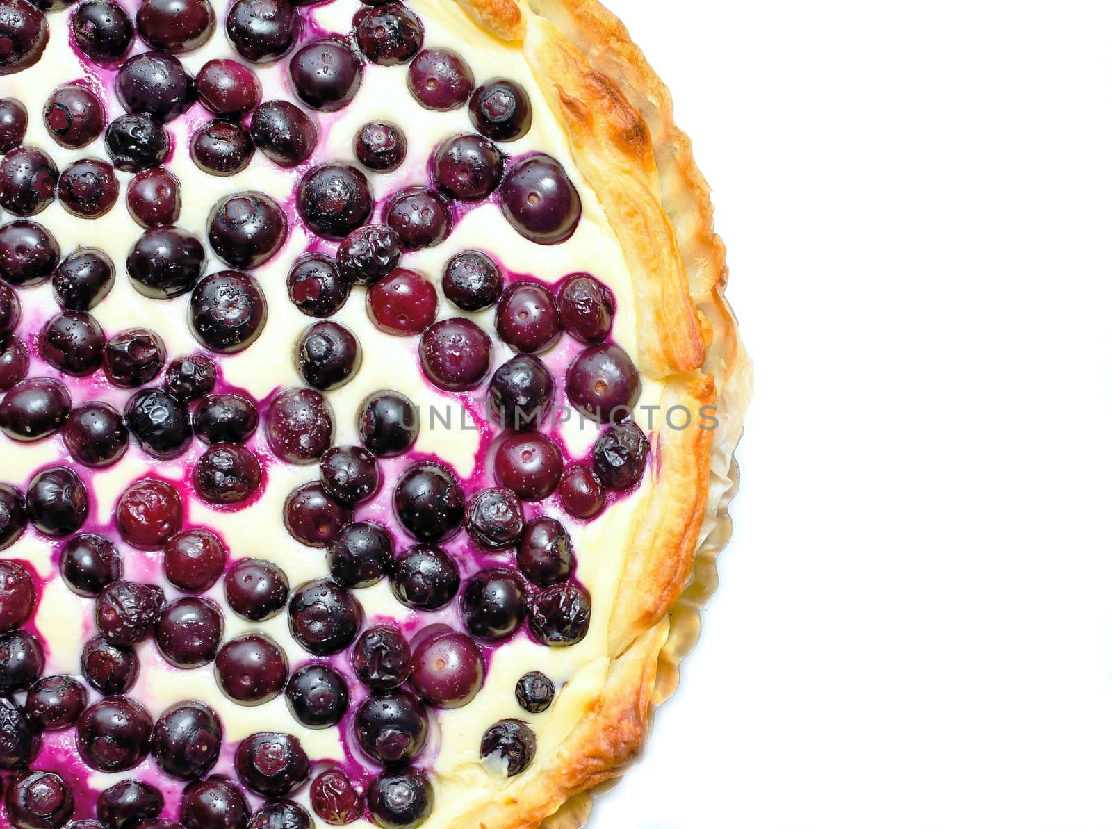 Top view on a blueberry cheese pie placed on a white background.