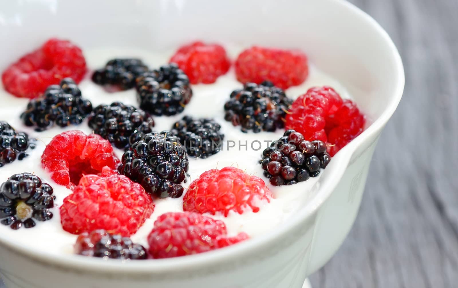 Blackberry and raspberry in the white yogurt.