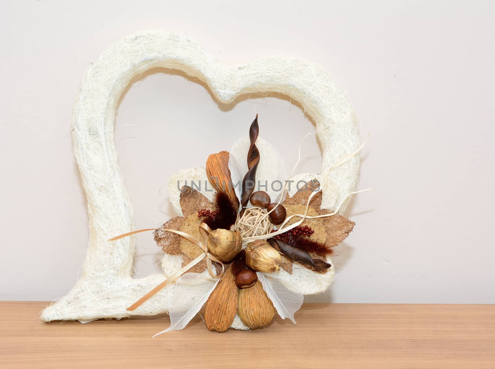 Closeup shot with autumn decoration on the table. Heart with nuts.