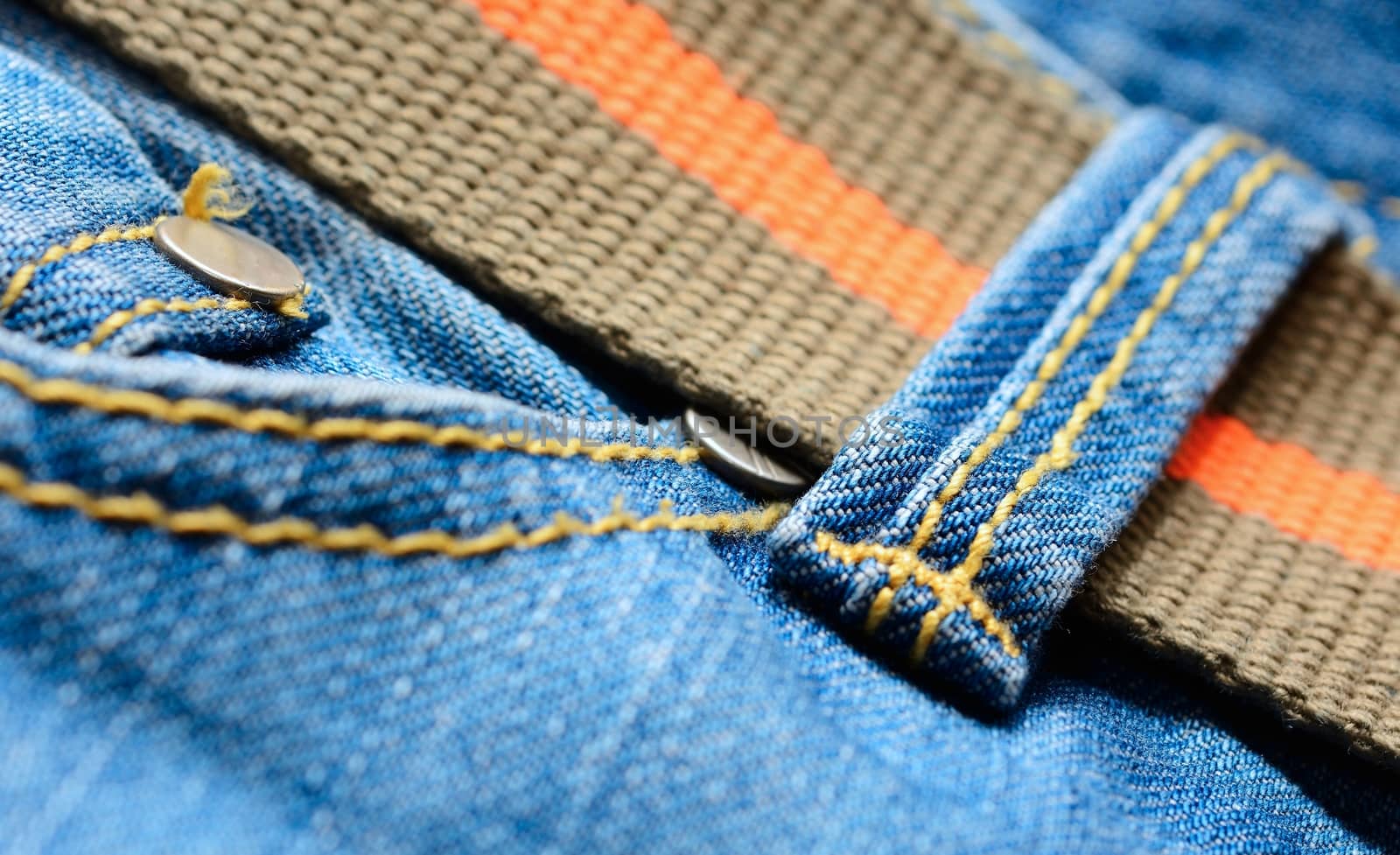 Blue jeans with orange belt, macro shot.