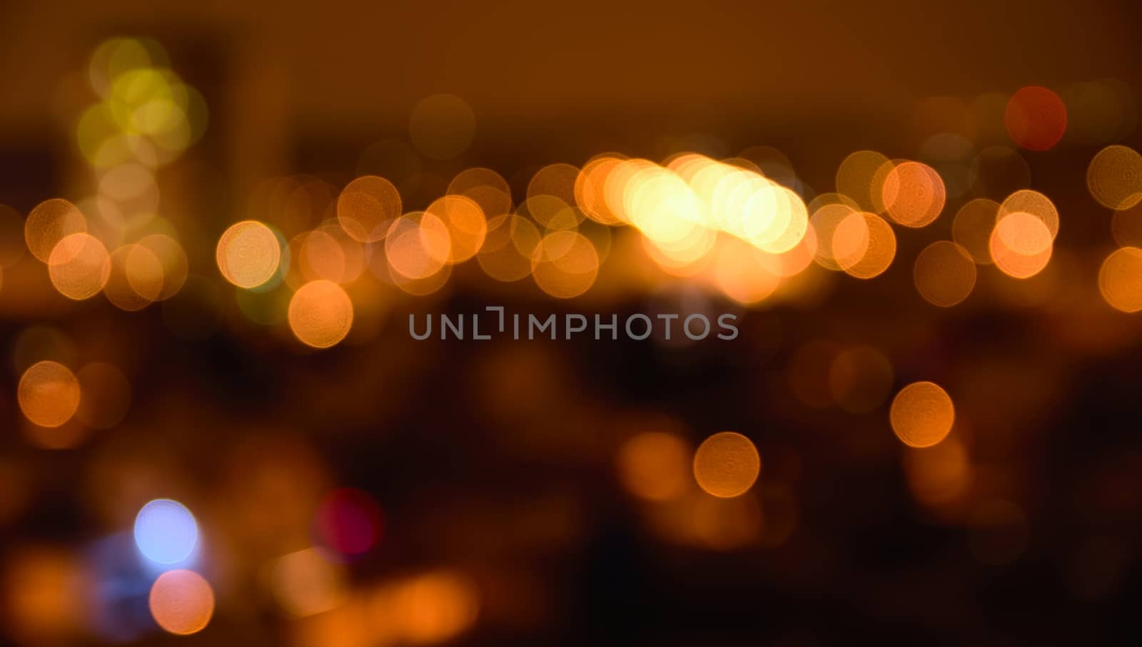 Abstract colorful defocused city lights with bokeh effects at night. Warm tone orange light background.