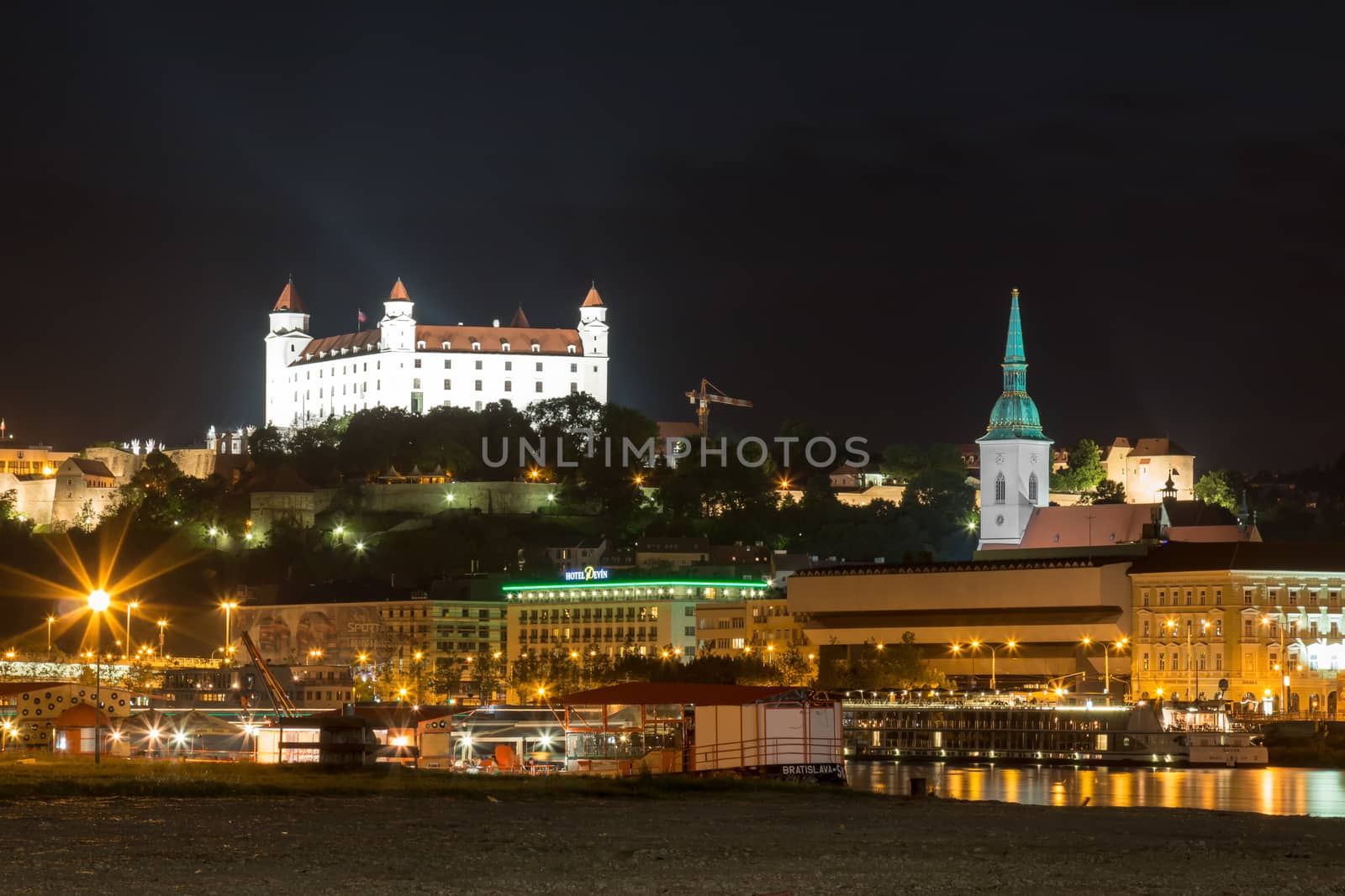 River Danube lining the old city of Bratislava, Slovakia. Night view on the hill with the castle and historical cathedral of St. Martin.