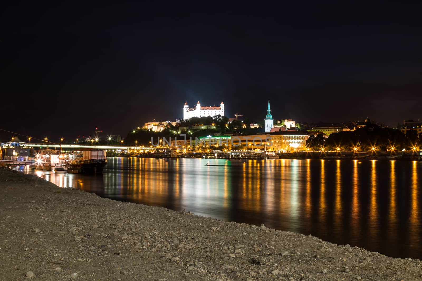 River Danube lining the old city of Bratislava, Slovakia. Night view on the hill with the castle and historical cathedral of St. Martin.