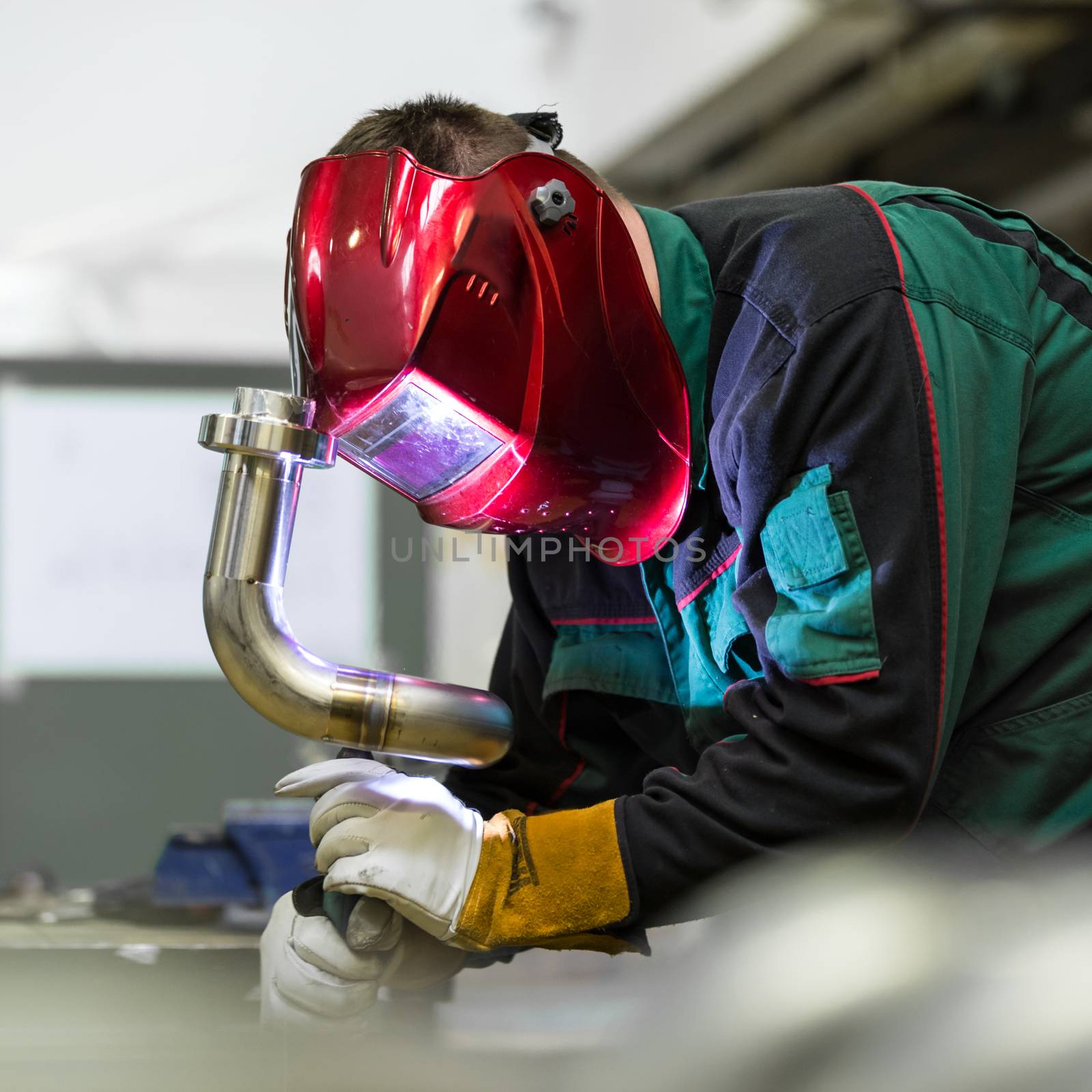 Industrial worker welding in metal factory. by kasto