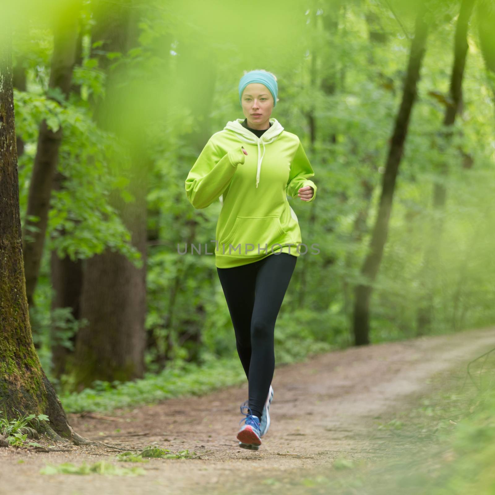 Sporty young female runner in forest.  Running woman. Female runner during outdoor workout in nature. Fitness model outdoors. Weight Loss. Healthy lifestyle. 