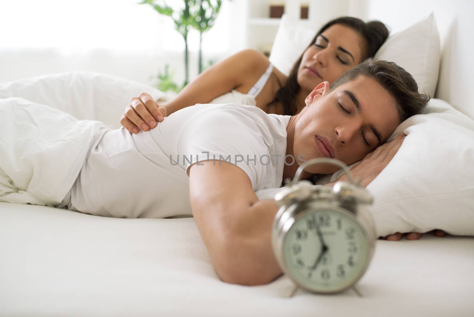 Young hugging couple sleeping on the bed in bedroom