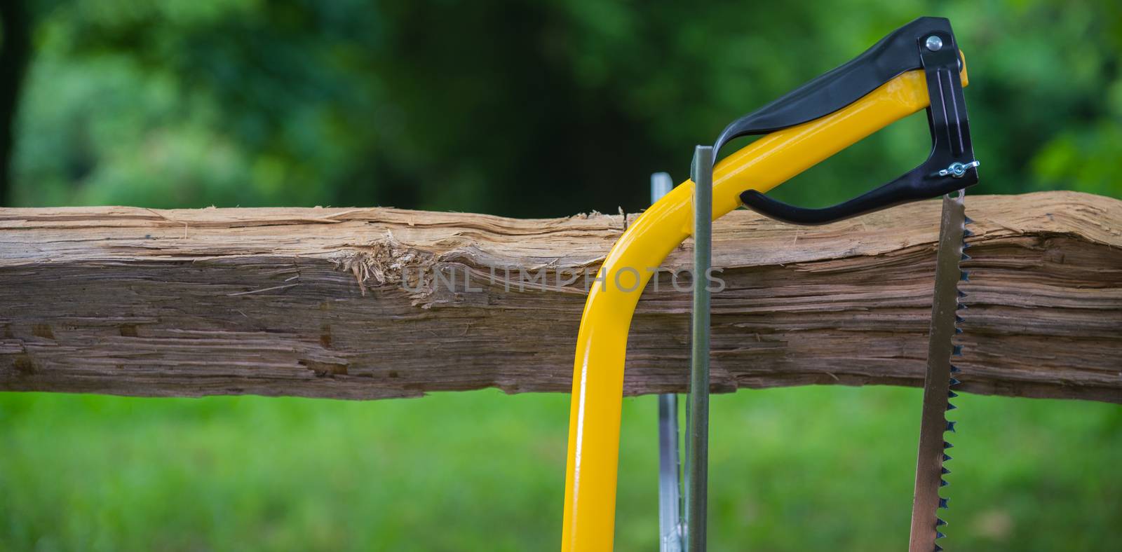 Wood saw standing on a firewood outdoor