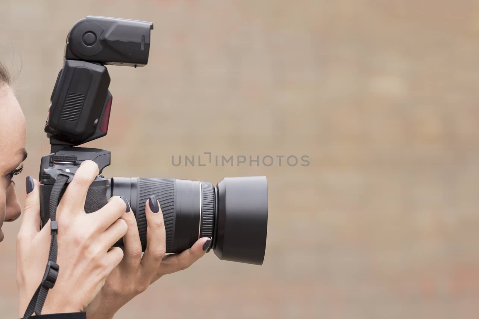 girl with beautiful manicure photographs on single-lens reflex camera