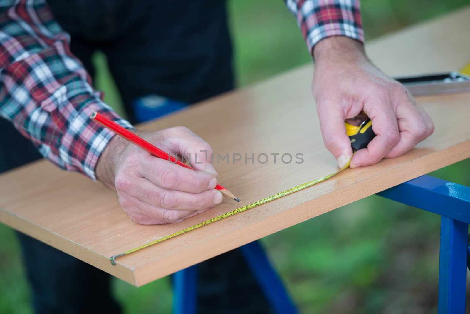 Drawing a melamine panel with a square and a pencil outdoor