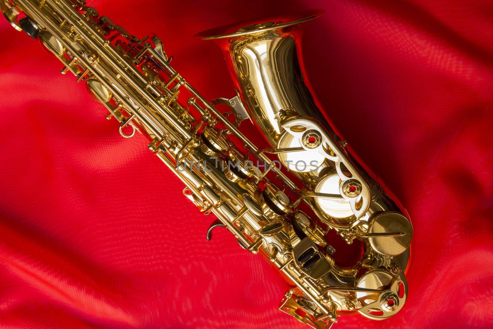 beautiful golden saxophone on delicate red silk background