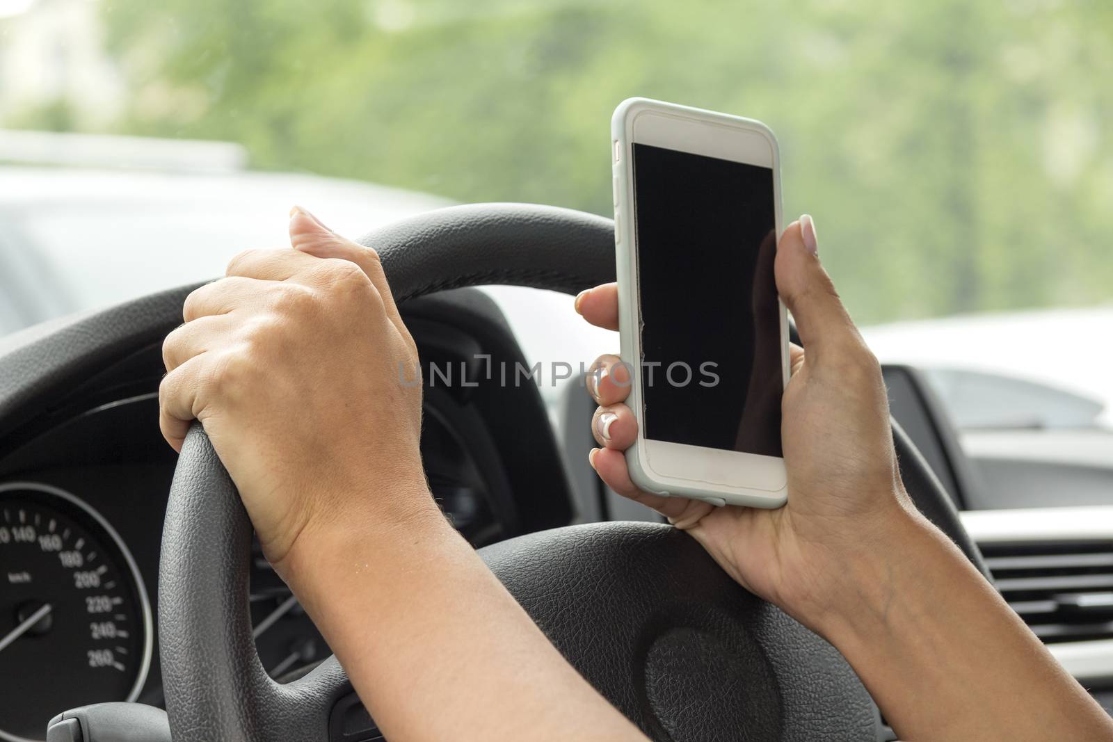 girl with a mobile phone behind the wheel in the saloon car