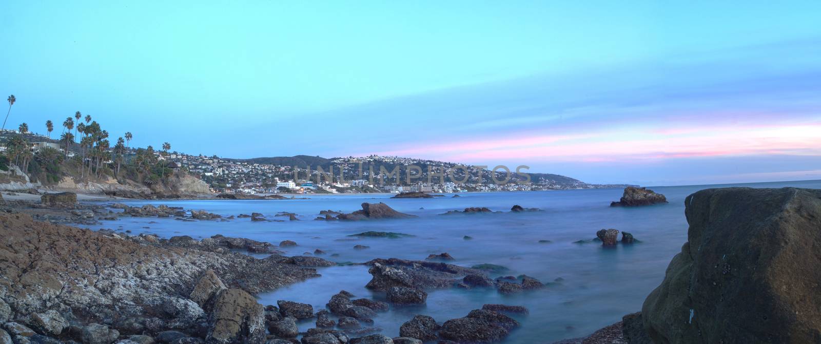 Long exposure of sunset over rocks, giving a mist like effect over ocean in Laguna Beach, California, United States