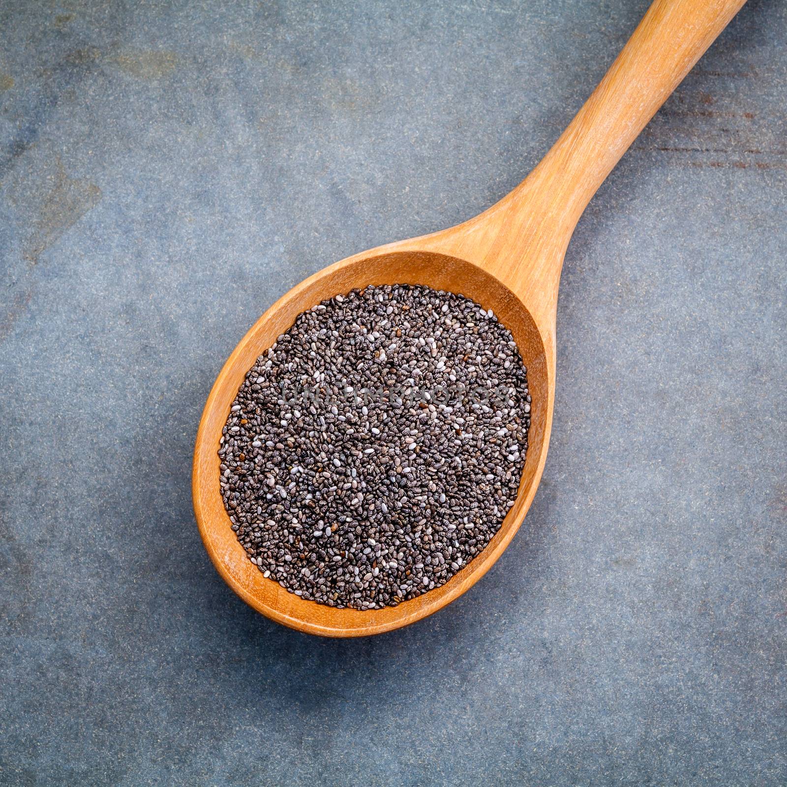 Nutritious chia seeds in wooden spoon for diet food ingredients.