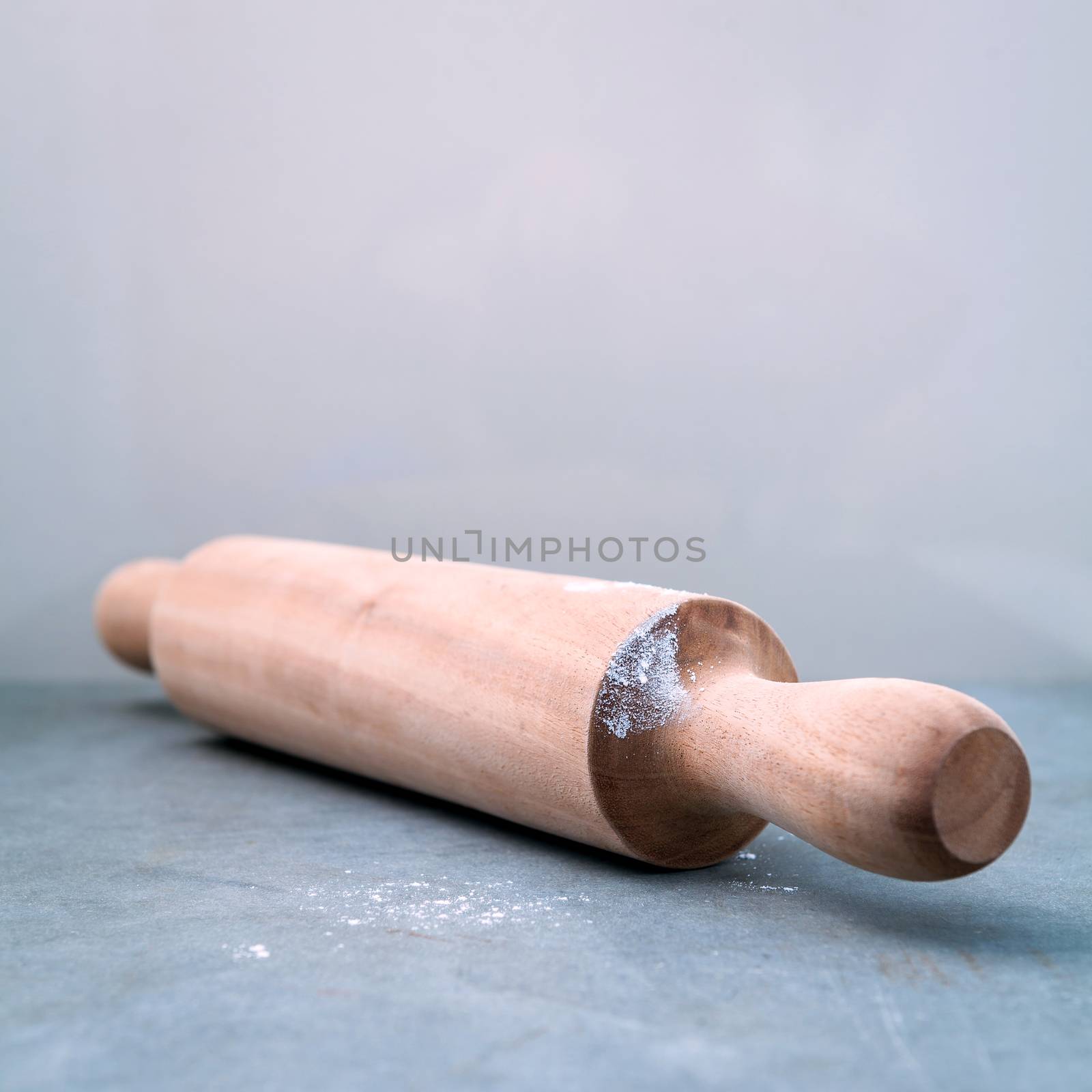 Kitchen rolling pin with flour on dark background selective focu by kerdkanno
