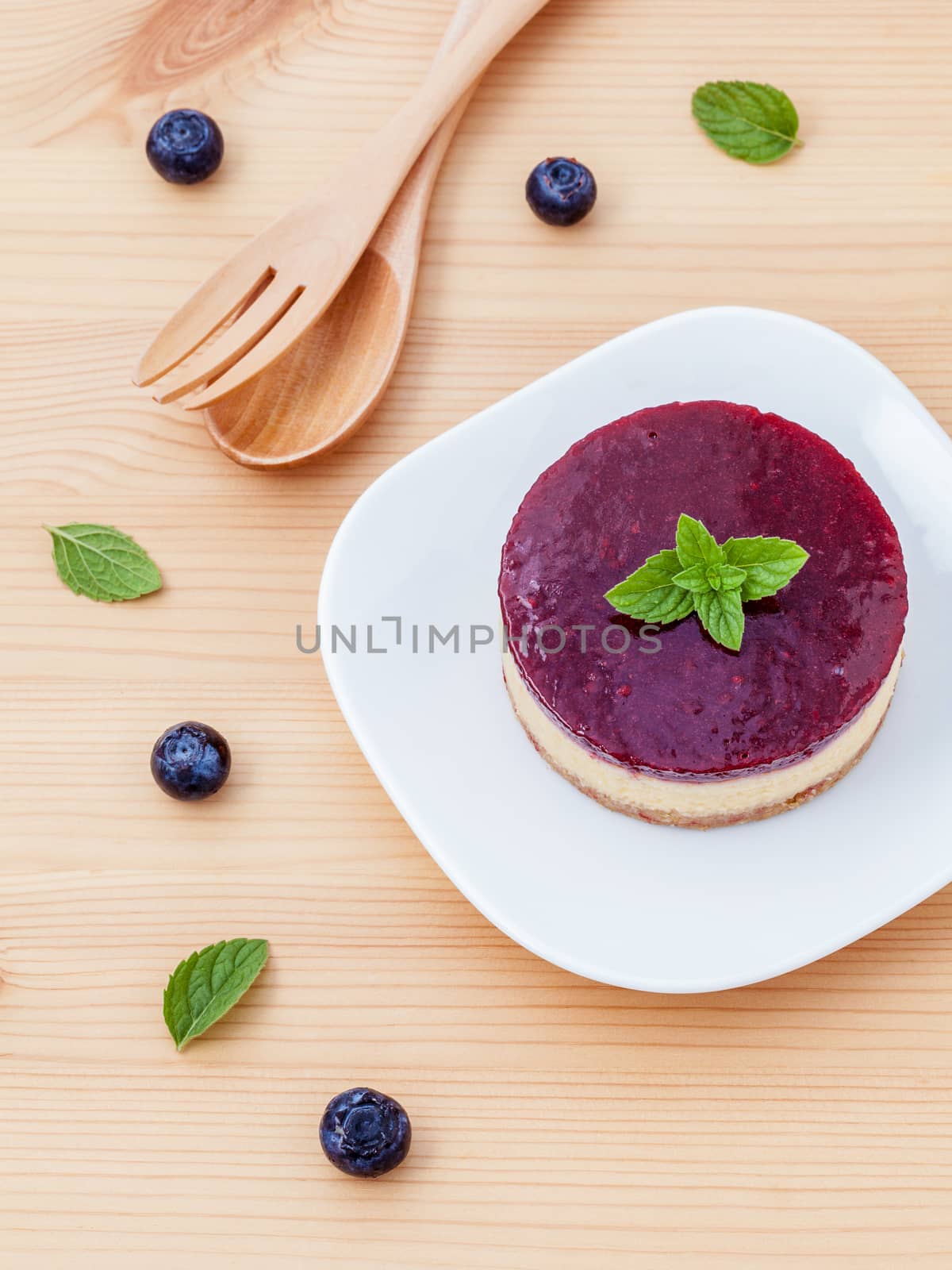 Blueberry cheesecake with fresh mint leaves on wooden background. Selective focus depth of field. 