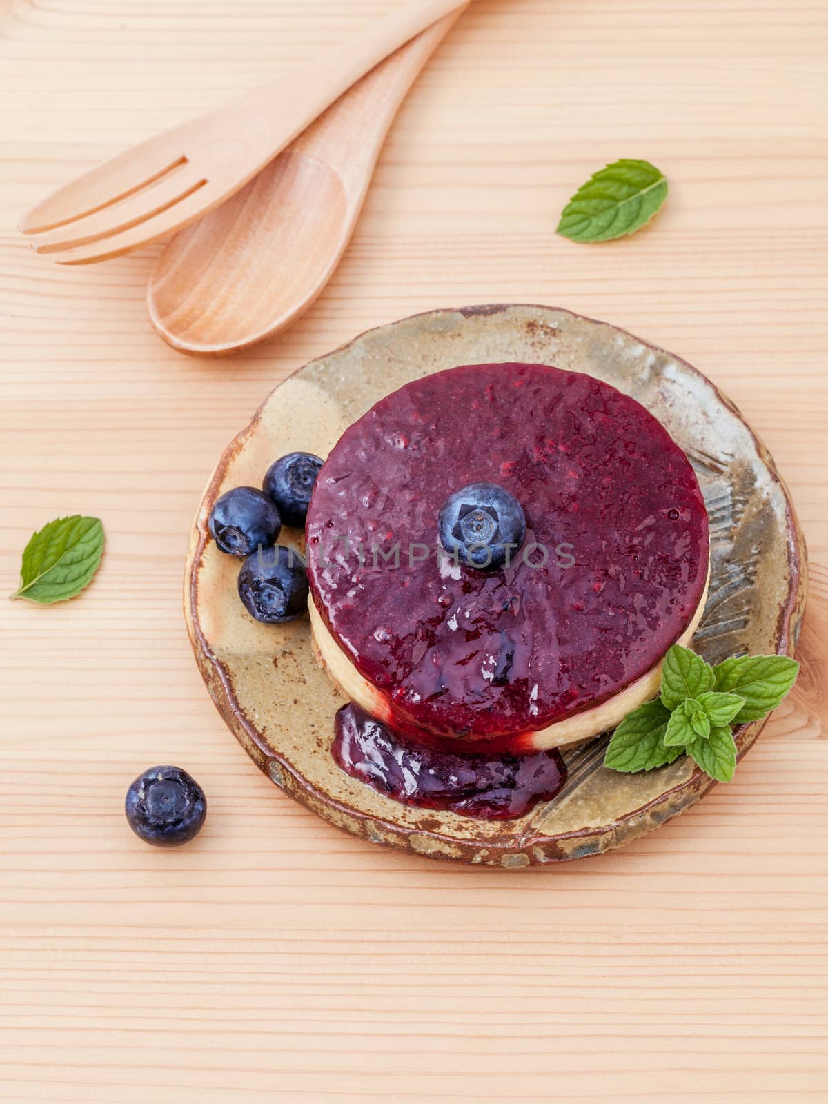 Blueberry cheesecake with fresh mint leaves on wooden background. Selective focus depth of field.