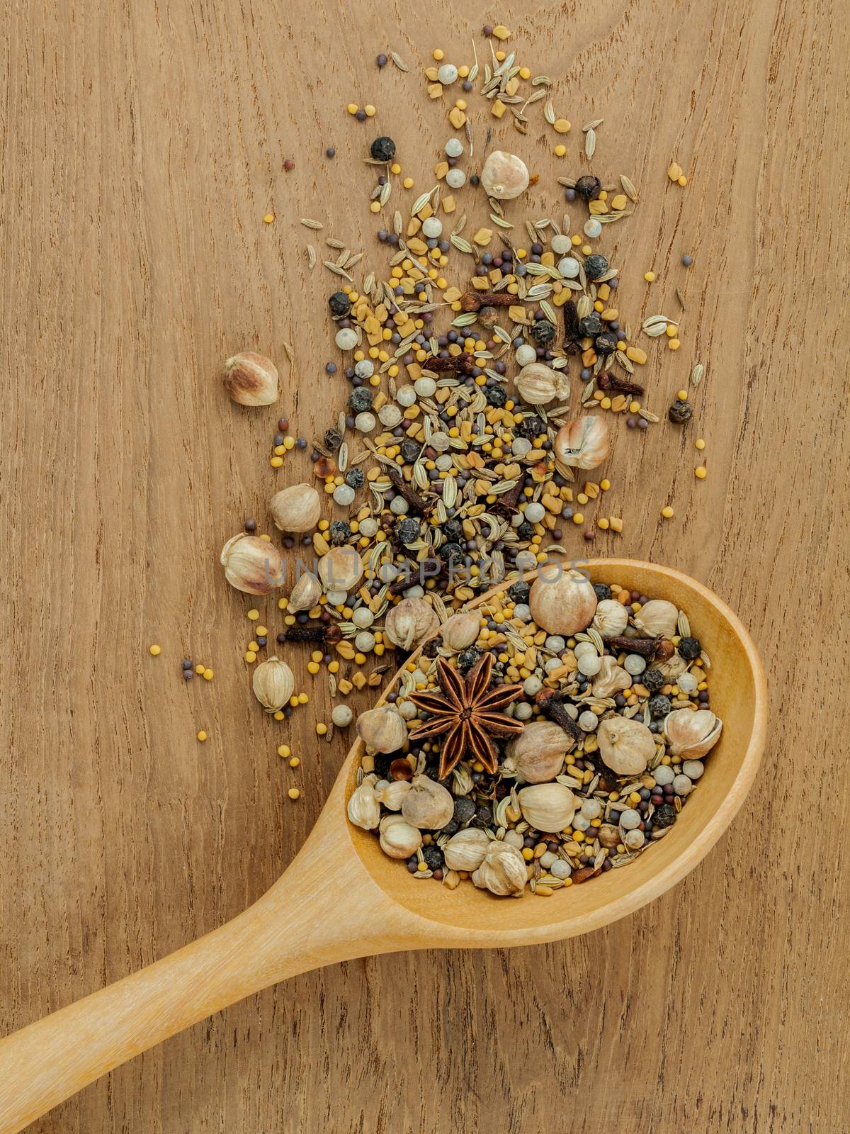 Assorted of spices  in wooden spoon  black pepper ,white pepper, black mustard,yellow mustard,fenugreek,cumin ,curry powder ,paprika and  fennel seeds on teak wood background.