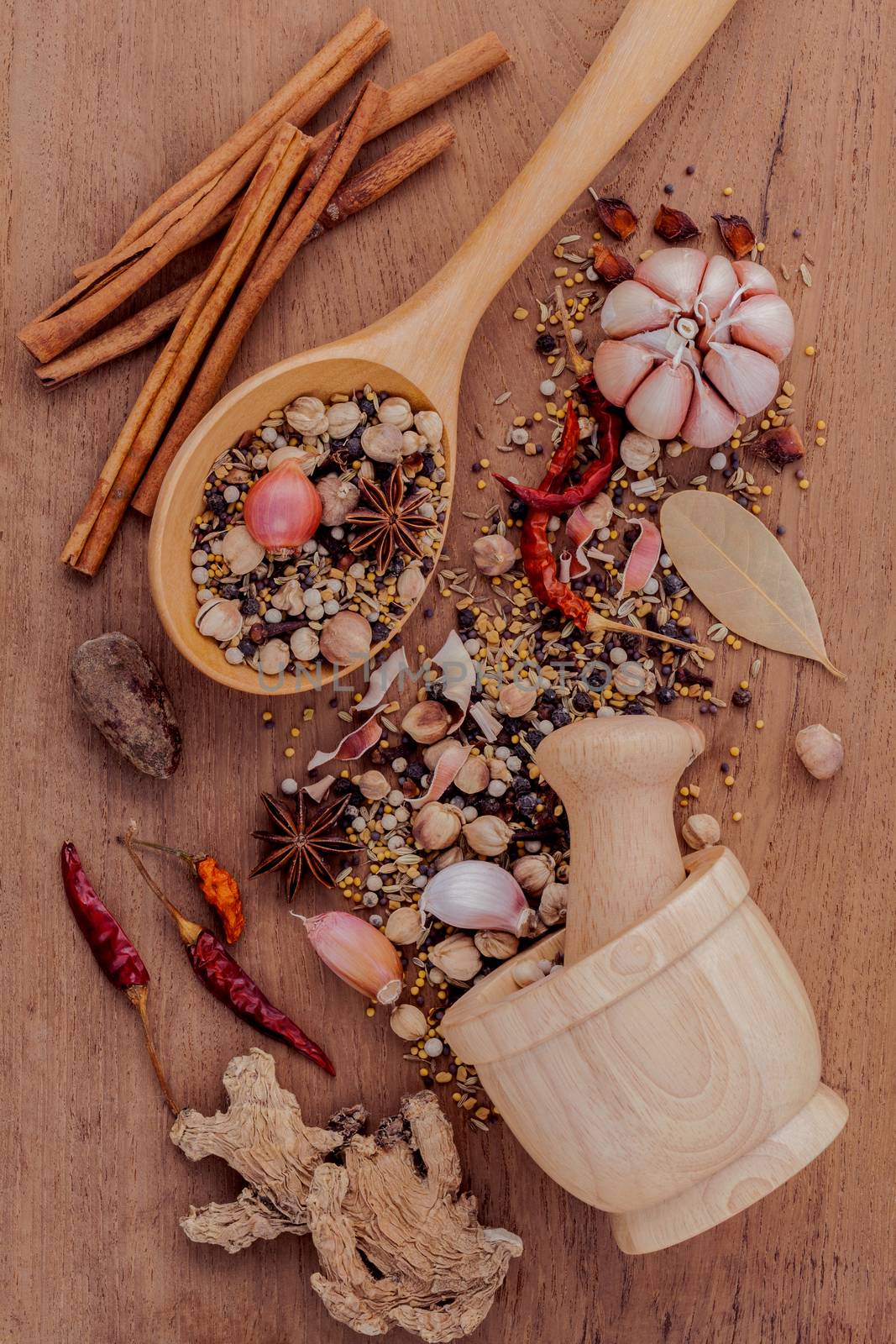 Assorted of spices  in wooden spoon  black pepper ,white pepper, black mustard,yellow mustard,fenugreek,cumin ,curry powder ,paprika and  fennel seeds on teak wood background.