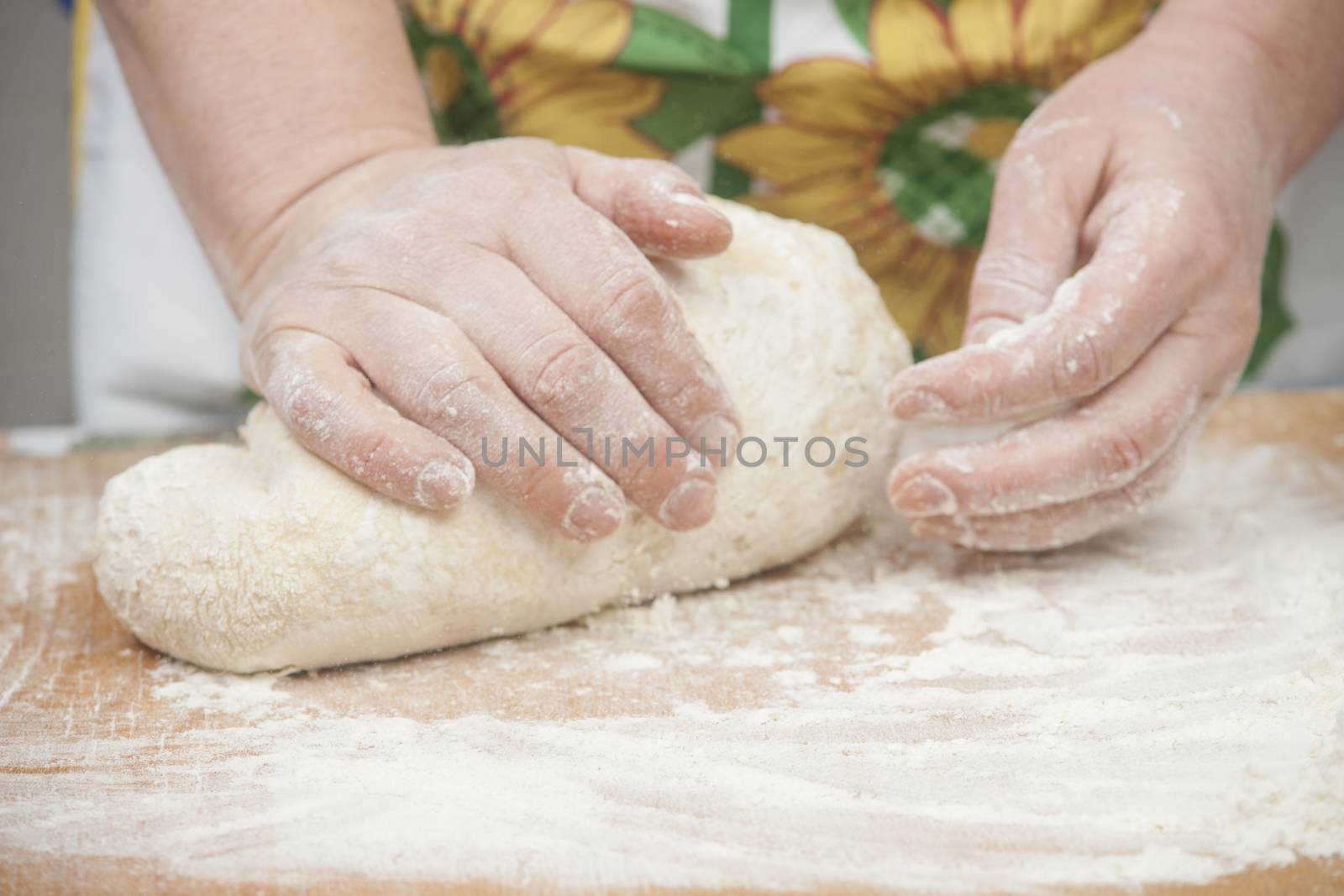 Women's hands preparing fresh yeast dough on wooden table