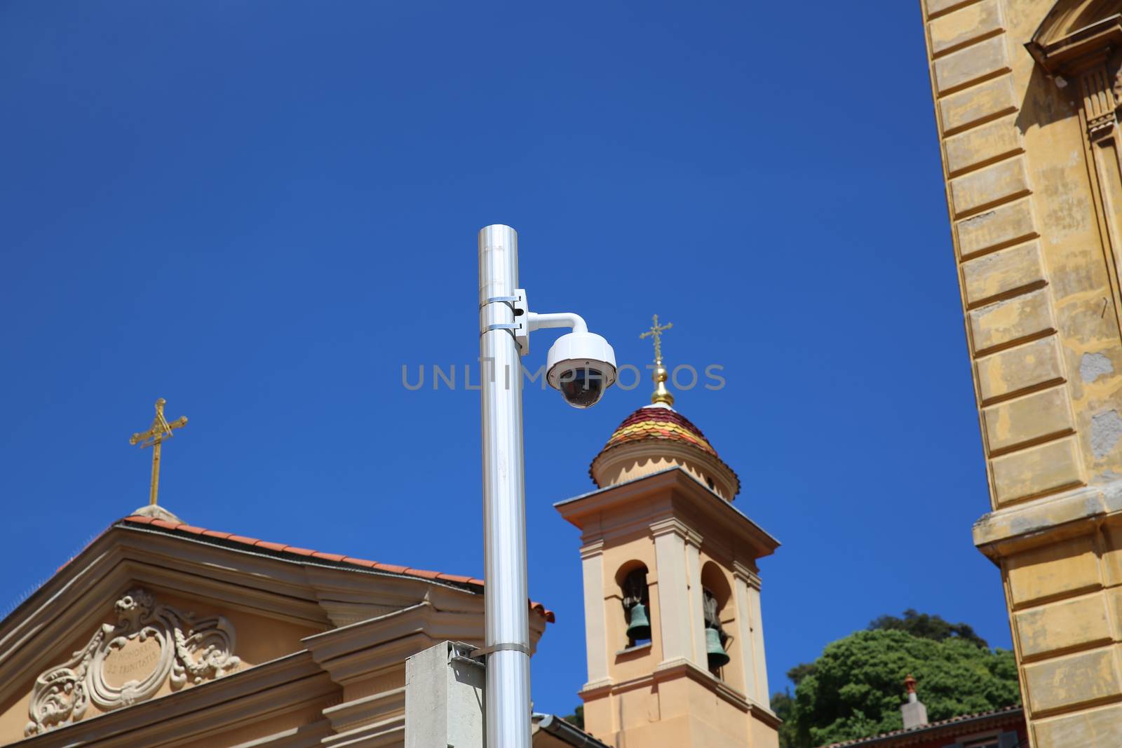 Dome Type Outdoor CCTV Camera on Street Lamp in Nice, Architecture of a Church in the Background