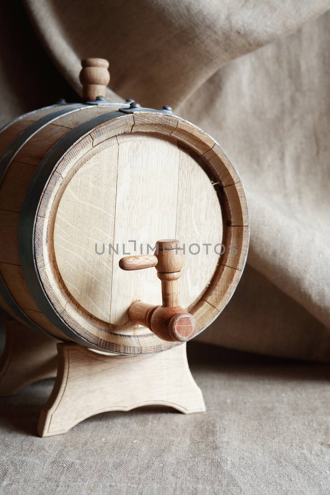 Nice oak barrel with faucet against vintage canvas background