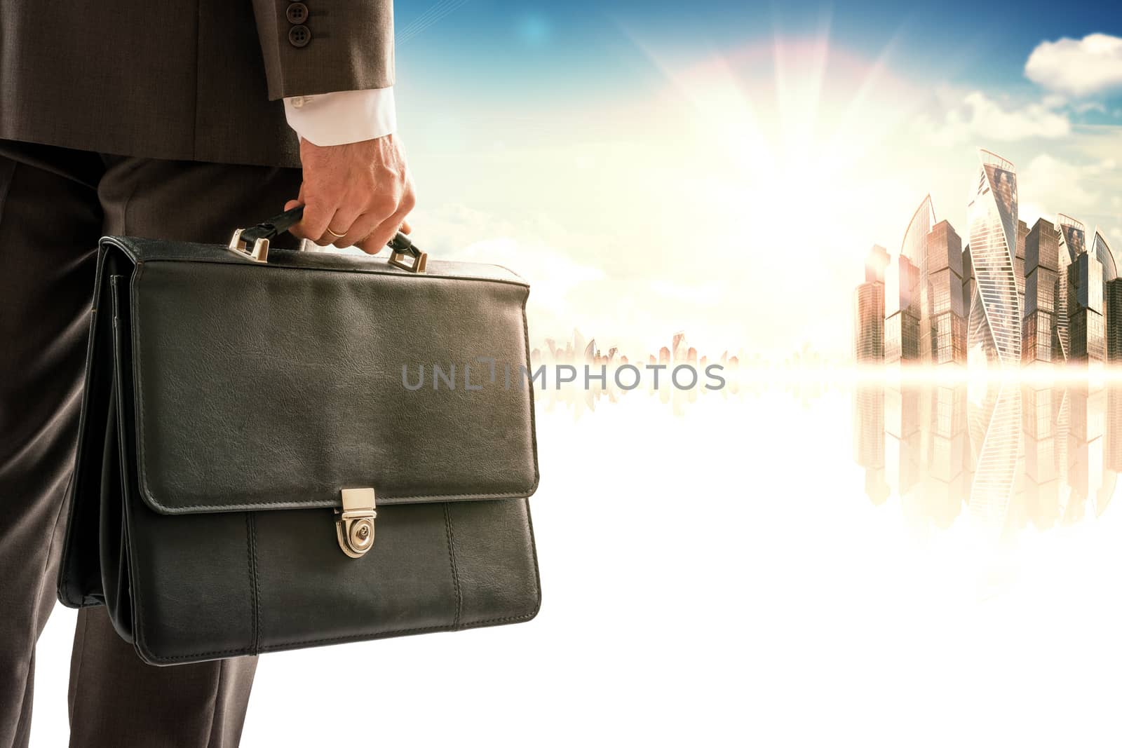 Businessman with suitcase against modern city by cherezoff