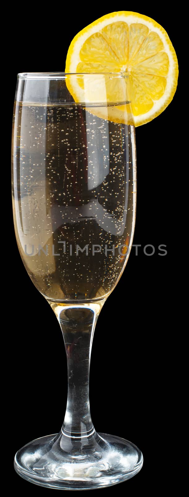 Champagne glass with lemon slice on black background