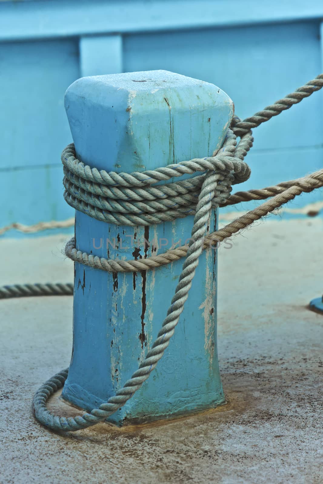 Blue fishing boat, tied to land by a rope