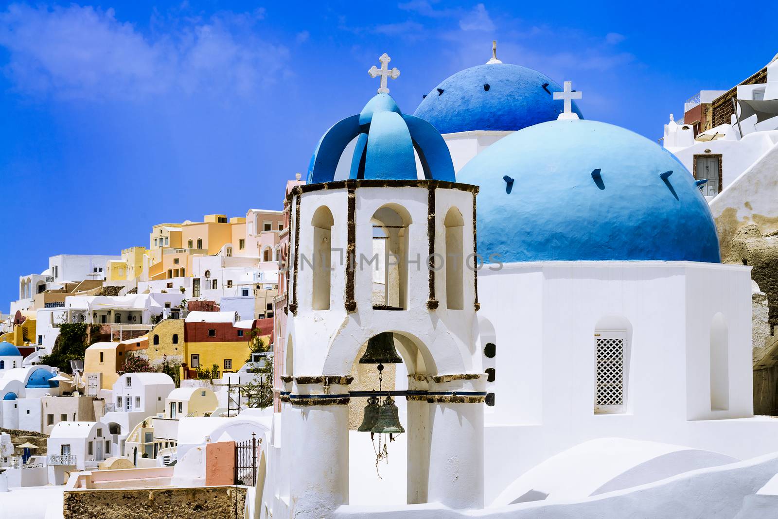 Oia town on Santorini island, Greece. Traditional and famous houses and churches with blue domes over the Caldera, Aegean sea