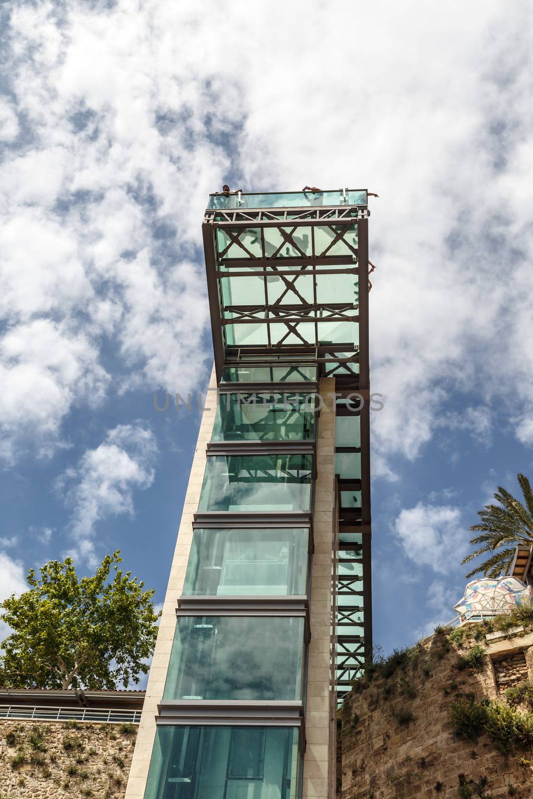 Bottom view of lift with glass observation terrace in Antalya Kaleici on cloudy blue sky background.