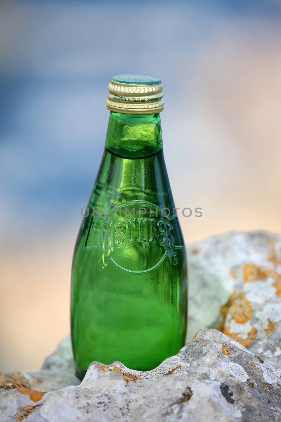 La Turbie, France - June 1, 2016: Perrier Sparkling Natural Mineral Water. Closeup of a Perrier Glass Bottle in The Nature