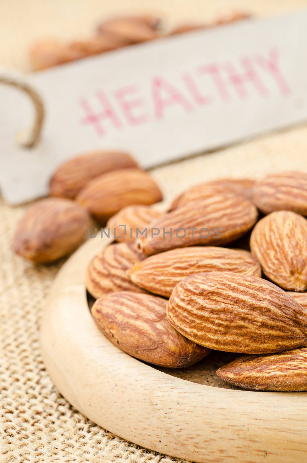 Close up almond with healthy tag on sack background.