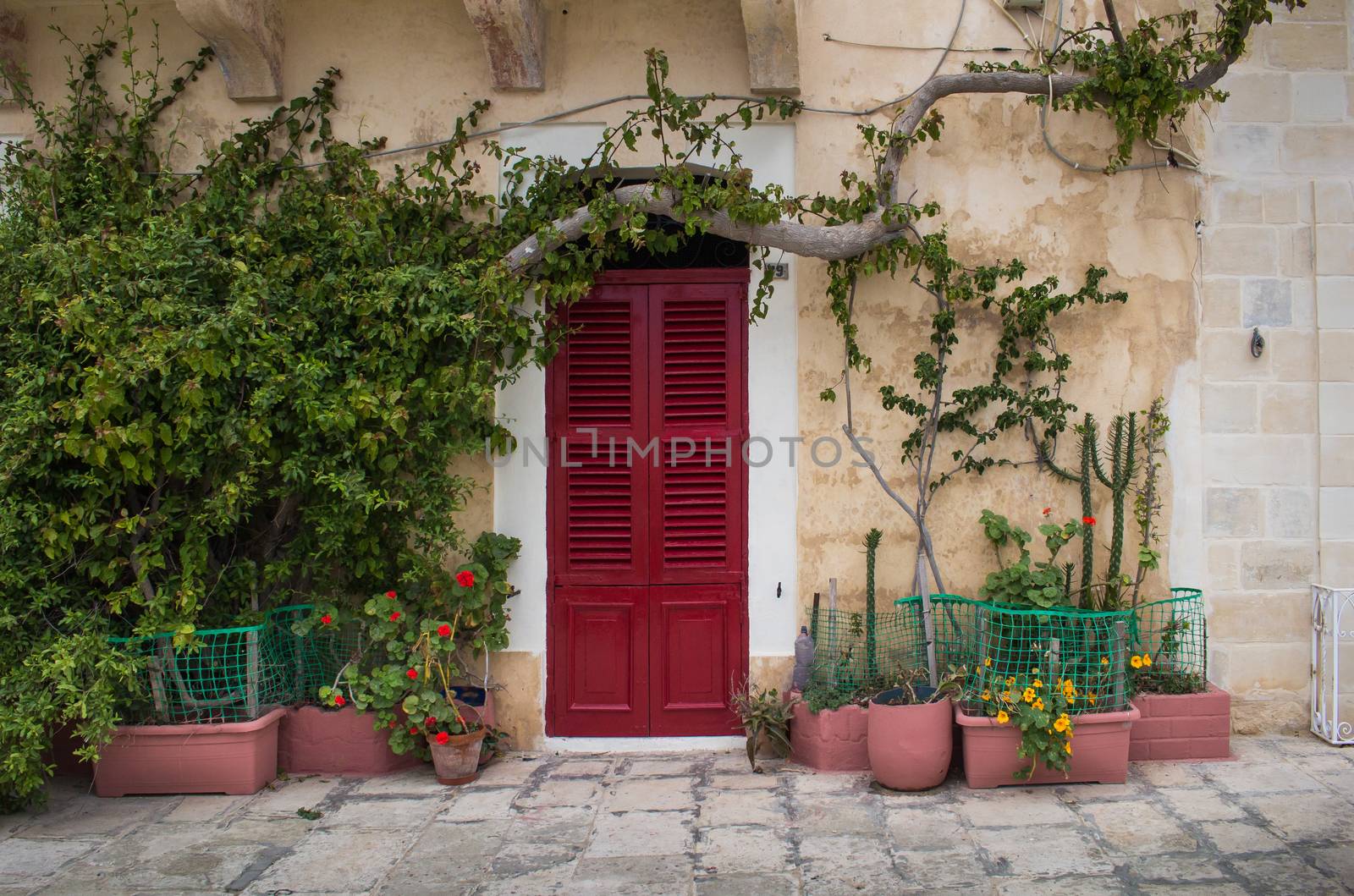 Red gate of a house at island Malta by YassminPhoto