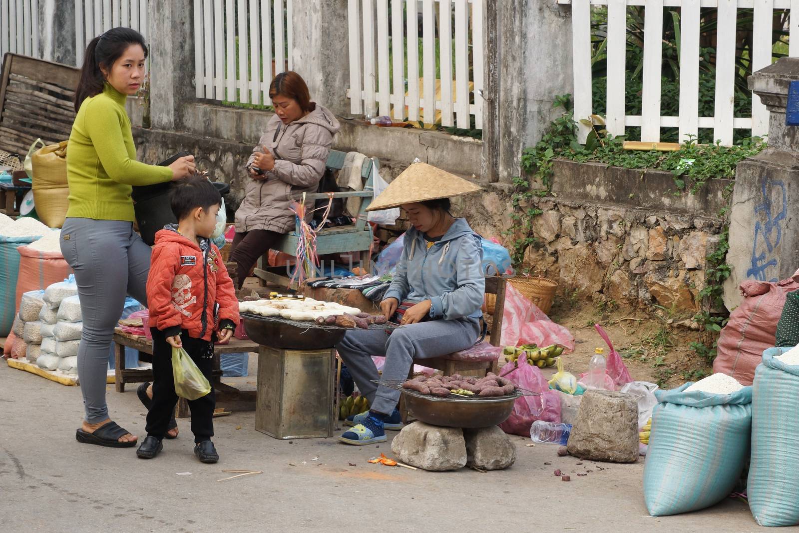 LUANG PRABANG, LAOS - FEBRUARY 13, 2016: People on the morning open air market of Luang Prabang on February 13, 2016 in Laos, Asia