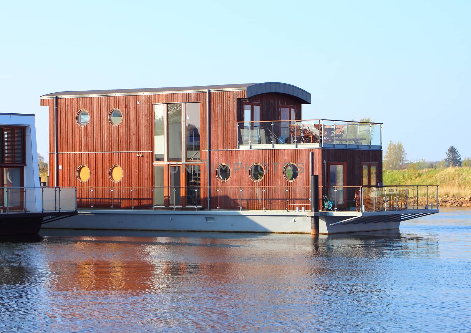 Wooden houseboat with two floors in lake by HoleInTheBox