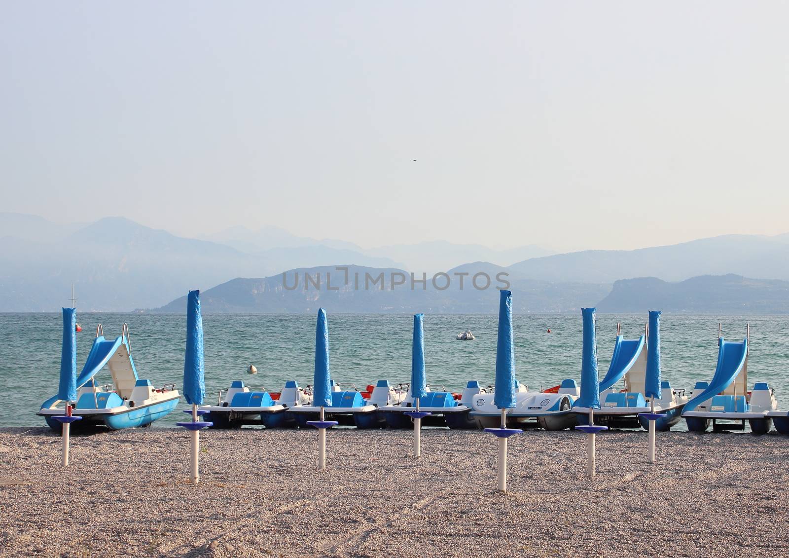 Water cycles and parasols at empty beach in the morning