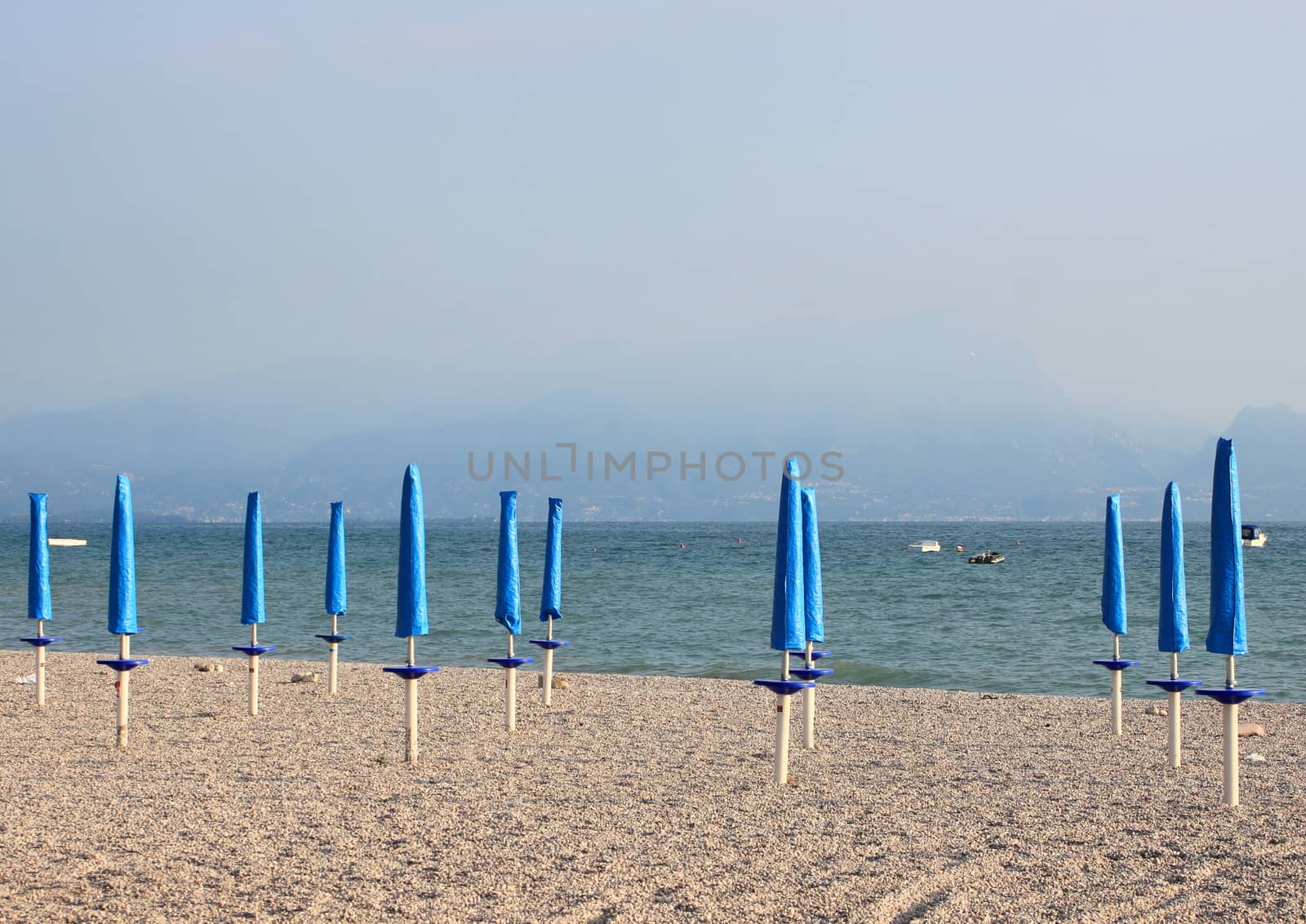 Closed parasols at rubble beach in the morning