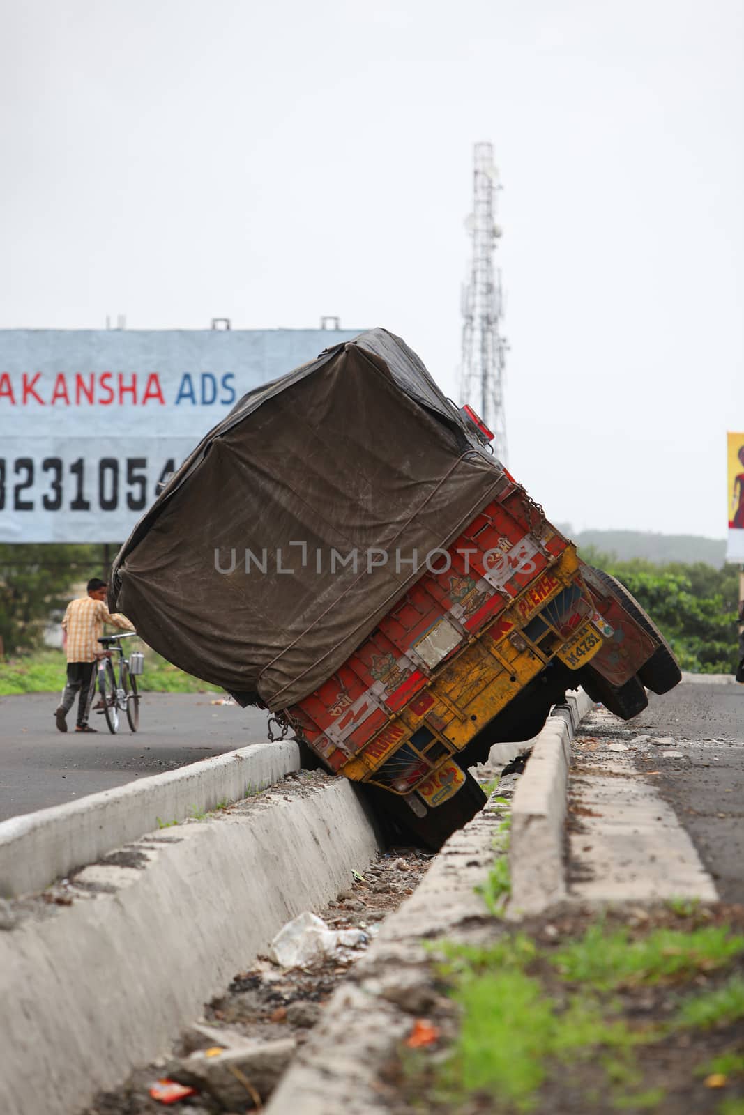 A truck toppled over into a drainage line during a freak accident in India.