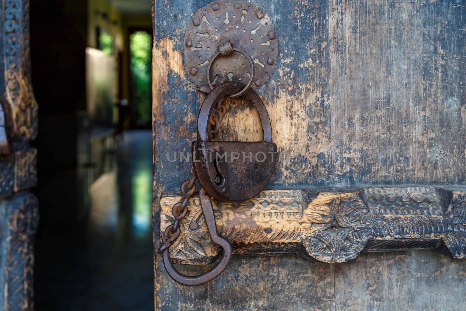 Close up front view of wooden old door, with historical rusty padlock.