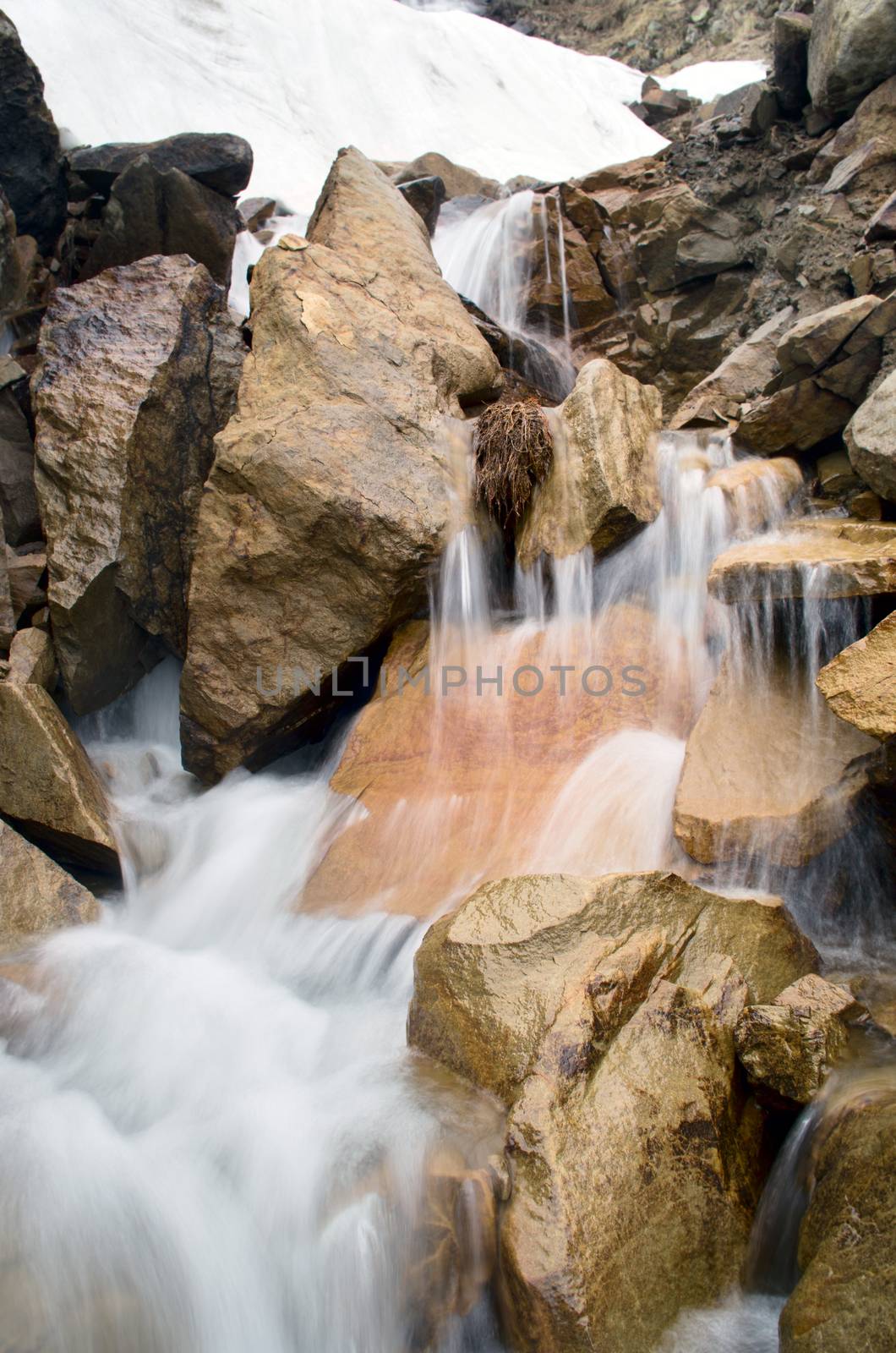 Stream among melting snow in a Carpathian Mountains