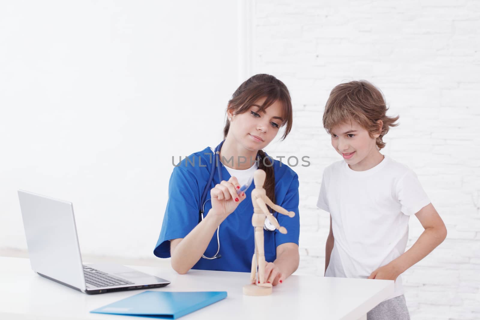 Doctor explain medicine to child using wooden doll