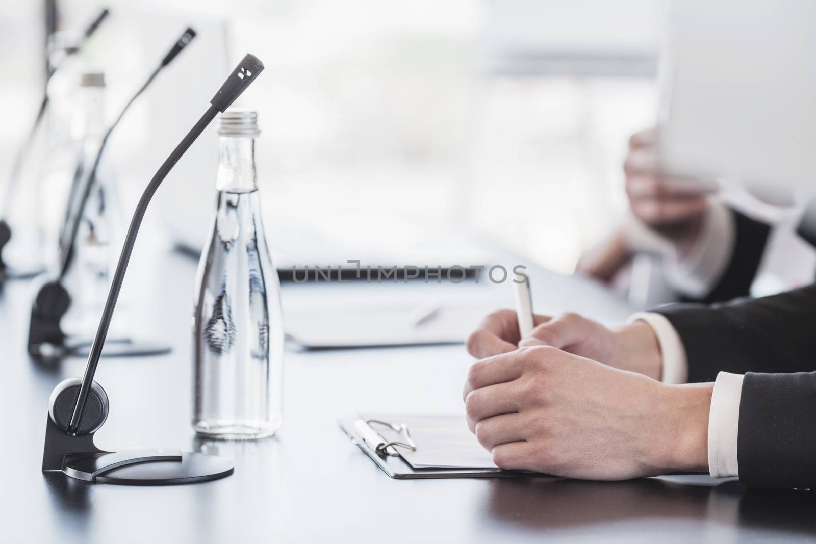 Microphones on table in conference room and business man hands 