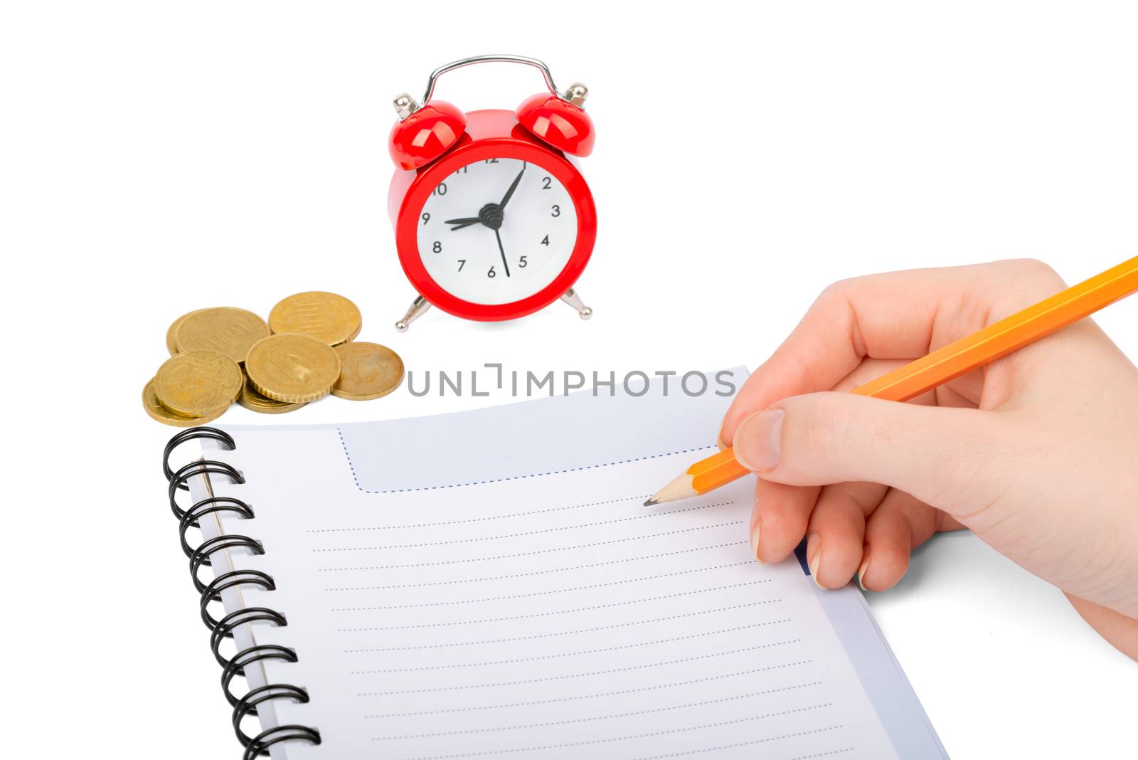 Hand writing in notebook with coins and alarm clock on isolated white background
