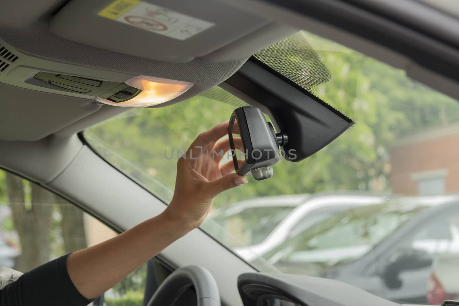 girl adjusts the rear view mirror in a car