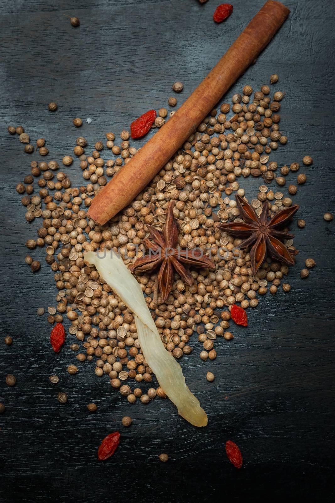 Spices and herbs on black wood background