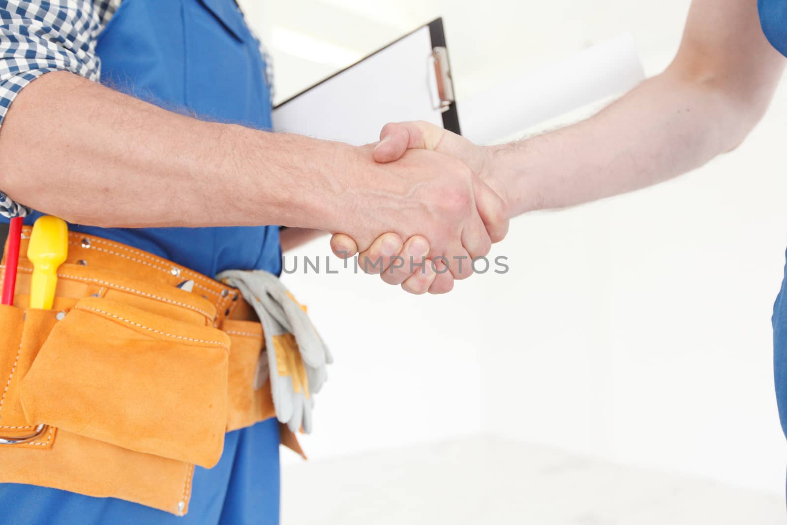 Two construction workers shaking hands, deal is finished concept